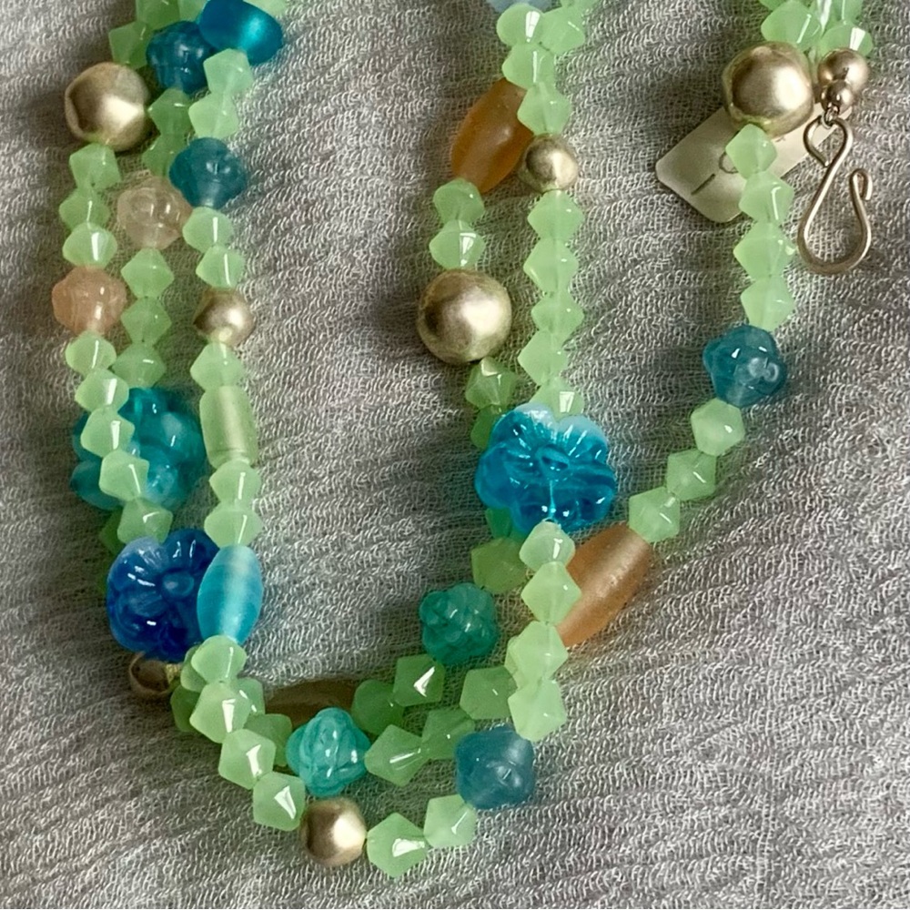 A three strand green themed beaded necklace